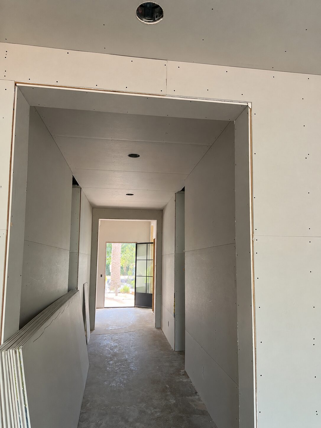 Hallway with drywall hung and taped on walls and ceiling on a Phoenix-area residential job