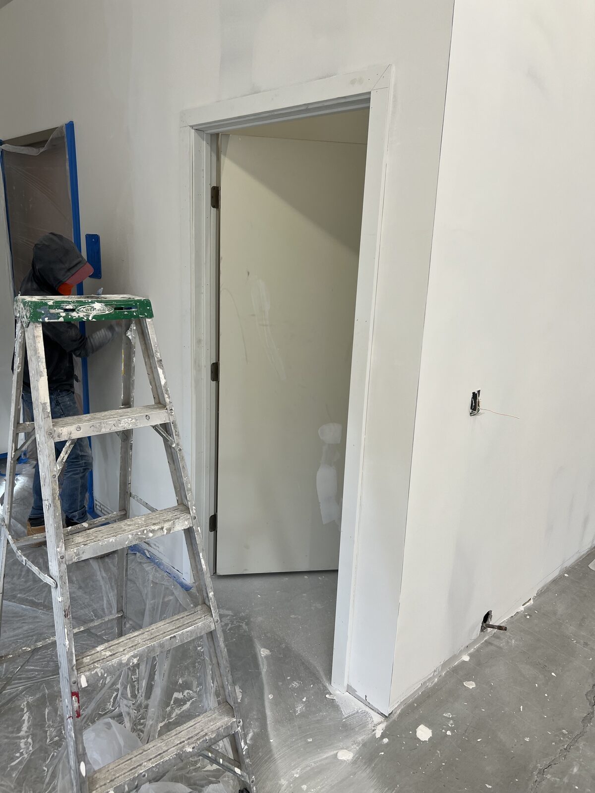 Proline Drywall crew member finishing a wall next to a framed doorway on a jobsite