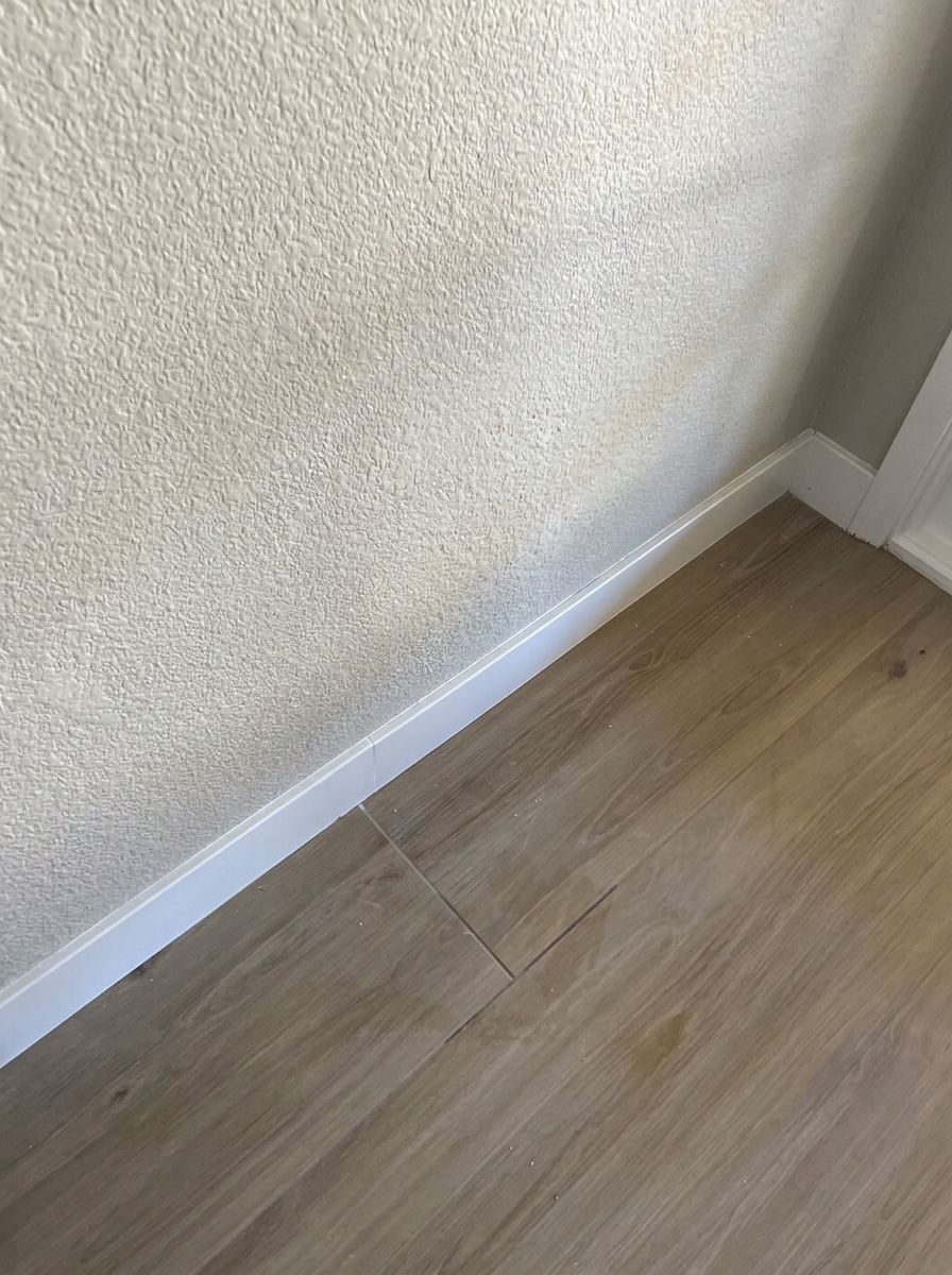 Finished wall with matched knockdown texture and clean baseboard after drywall repair